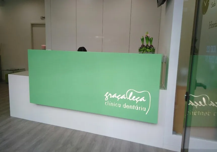 Recepção da Clínica Dentária Graça Leça com balcão verde e logótipo da clínica